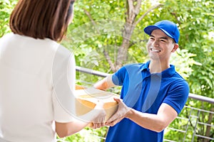 Delivery man in blue uniform delivering parcel box to a woman