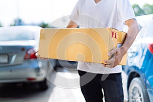 Delivery man carrying cardboard box for sending deliver to customer