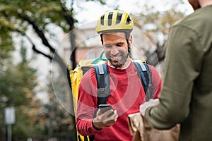 Delivery man checking food order with smartphone