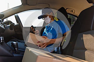 Delivery man courier holding deliveries out boxes and using mobile phone contact the customer