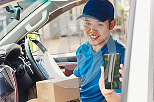 Delivery man courier online holding deliveries out boxes inside the car and using mobile smartphone checking location