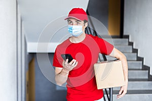 Delivery man courier online holding deliveries out boxes and using mobile phone contact the customer he protective face mask