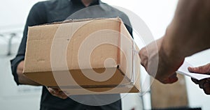 Delivery man delivering package to customer, close up at and and box