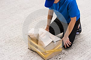 Delivery man he emotional courier hold damaged cardboard box is broken