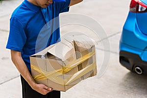 Delivery man he emotional courier hold damaged cardboard box is broken