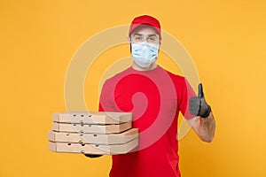 Delivery man employee in red cap blank t-shirt uniform mask gloves give food order pizza boxes isolated on yellow