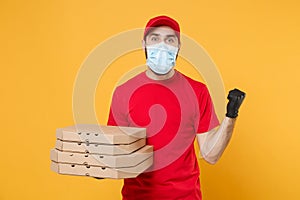 Delivery man employee in red cap blank t-shirt uniform mask gloves give food order pizza boxes isolated on yellow