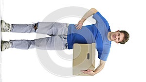 Delivery man, full-length, on a white background, with a box, hand on hip