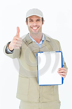 Delivery man gesturing thumbs up while showing clipboard