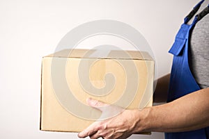 Delivery man giving cardboard box to female hand