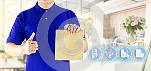 Delivery man hand holding paper bag in blue uniform and icon media for delivering package order online fast food delivery service