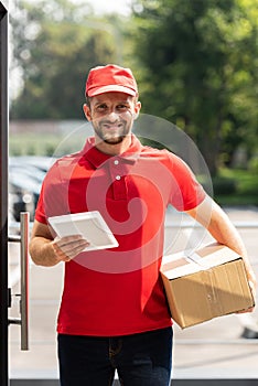 Delivery man holding box and digital