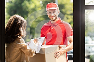 Delivery man holding box near woman