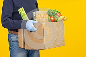 Delivery man holding cardboard boxes in medical rubber gloves.