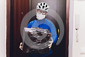 Delivery man holding cardboard boxes in medical rubber gloves and mask. copy space. Fast and free Delivery transport