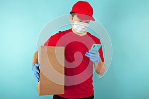 Delivery man holding cardboard boxes in medical rubber gloves and mask. copy space. Fast and free Delivery transport