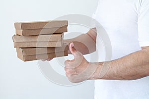 Delivery man holding cardboard boxes in white t-shirt