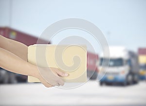 Delivery man holding parcel box for customer service on blur transportation background