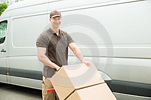 Delivery Man Holding Trolley With Cardboard Boxes