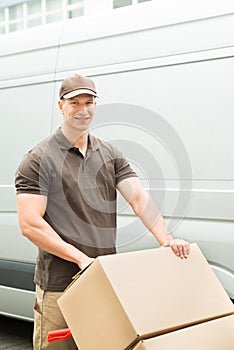 Delivery Man Holding Trolley With Cardboard Boxes