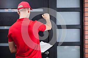 Delivery man knocking on the client's door photo