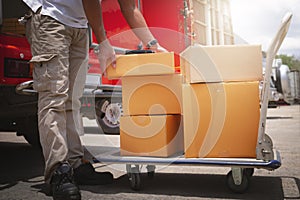 Delivery Man Lifting Package Boxes on The Cart. Worker Courier. Delivery Trucks. Delivering Shipment to Customers.