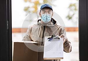 delivery man in mask with parcel box and clipboard