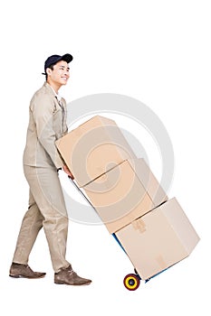 Delivery man moving luggage trolley with cardboard boxes