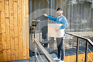 Delivery man with package near the house