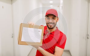 Delivery man with parcel box in corridor