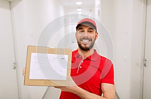 Delivery man with parcel box in corridor