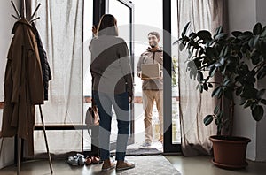 delivery man with parcel box and customer at home