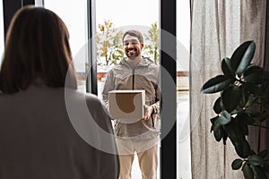 delivery man with parcel box and customer at home