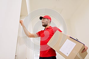 Delivery man with parcel box knocking on door