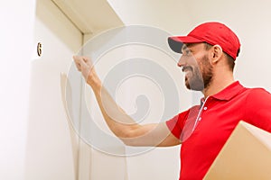 Delivery man with parcel box knocking on door