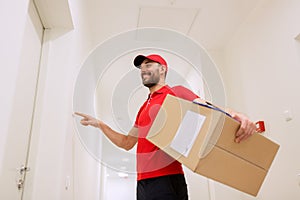 Delivery man with parcel box ringing doorbell