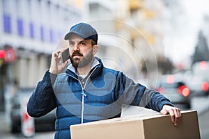 Delivery man with a parcel box on the street.