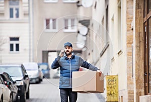 Delivery man with a parcel box on the street.