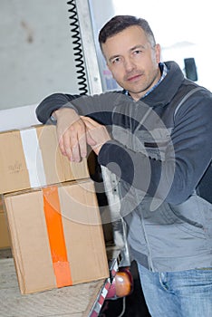 Delivery man with parcel near cargo truck shipping service