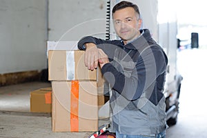 Delivery man with parcel near cargo truck shipping service