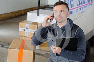 Delivery man with parcel near cargo truck shipping service