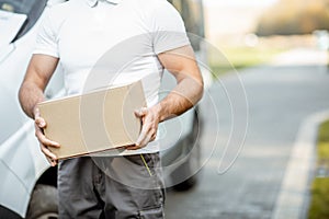 Delivery man with parcel outdoors