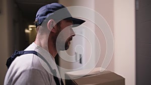 Delivery man with parcel ringing door bell