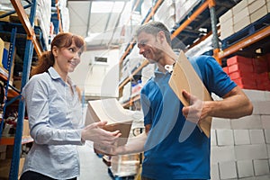 Delivery man passing parcel to warehouse manager