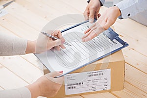 Delivery man presenting receiving form in post office