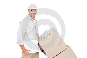 Delivery man pushing trolley of boxes on white background