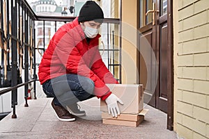 Delivery man putting parcel cardboard box under the door entrance