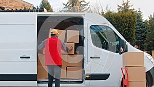 Delivery man putting parcel into the van. Delivery during covid outbreak