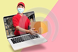 Delivery man in red shirt with hygienic mask, holding goods order in package parcel out from laptop computer with warehouse