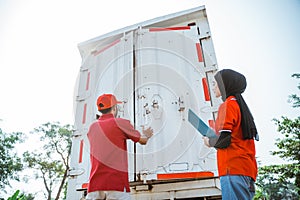 delivery man in red uniform closing the door of container